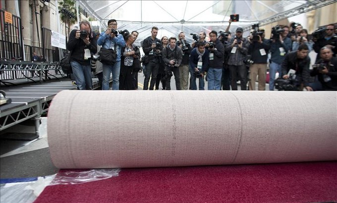 Miembros de la prensa toman fotografías de la alfombra roja que será usada en la ceremonia de los Óscar el 26 de febrero de 2014. EFE